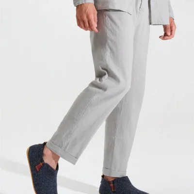 Graue Filz-Slipper mit Kork-Sohle, getragen zu heller Leinenhose.