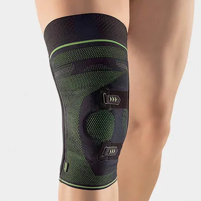 Kniebandage in Schwarz-Grün mit Klettverschlüssen und Patellaöffnung am Bein.
