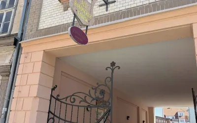 Torbogen mit schmiedeeisernem Tor, Schild "Alte Handschuhfabrik" und Passage