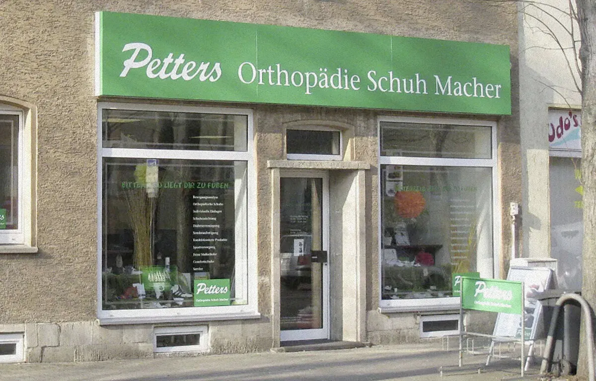 Ladenfassade mit grünem Schild "Petters Orthopädie Schuh Macher" in Bitterfeld.