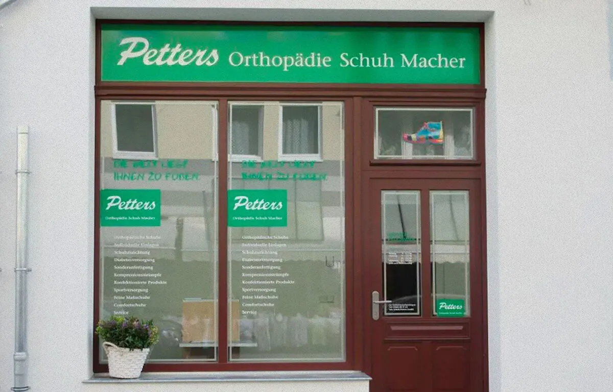 Ladenfassade mit grünem Schild „Petters Orthopädie Schuh Macher" in Halle