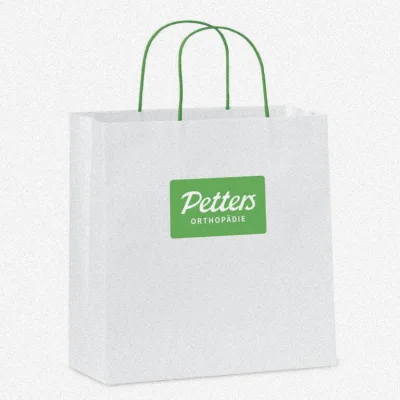 Weiße Papiertragetasche mit grünen Kordelgriffen und Petters Orthopädie Logo