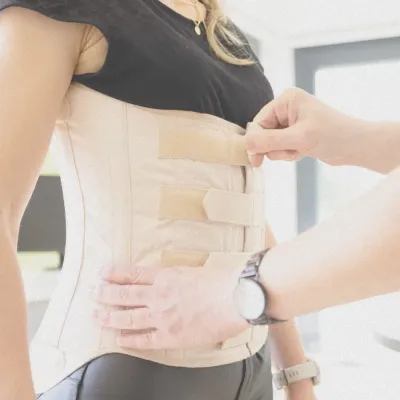 Anpassung eines orthopädischen Mieders mit Klettverschlüssen am Rumpf