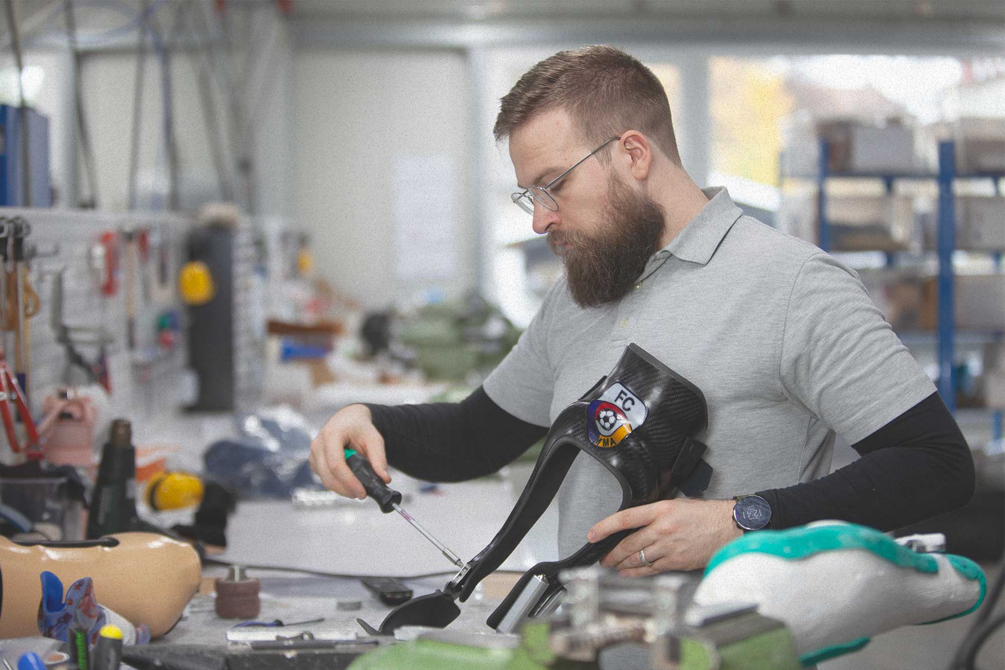 Techniker schraubt an einer Carbon-Sprintprothese in der Werkstatt.