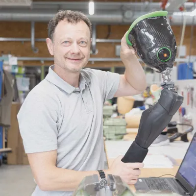 Techniker hält Beinprothese mit Carbonschaft in der Werkstatt.