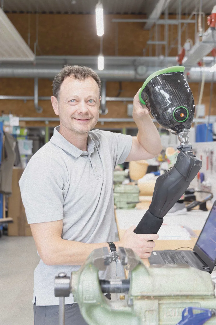Techniker hält Beinprothese mit Carbonschaft in der Werkstatt.